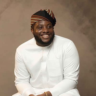 A headshot of Oluwatumininu Oyetayo. He is grinning at the camera.
